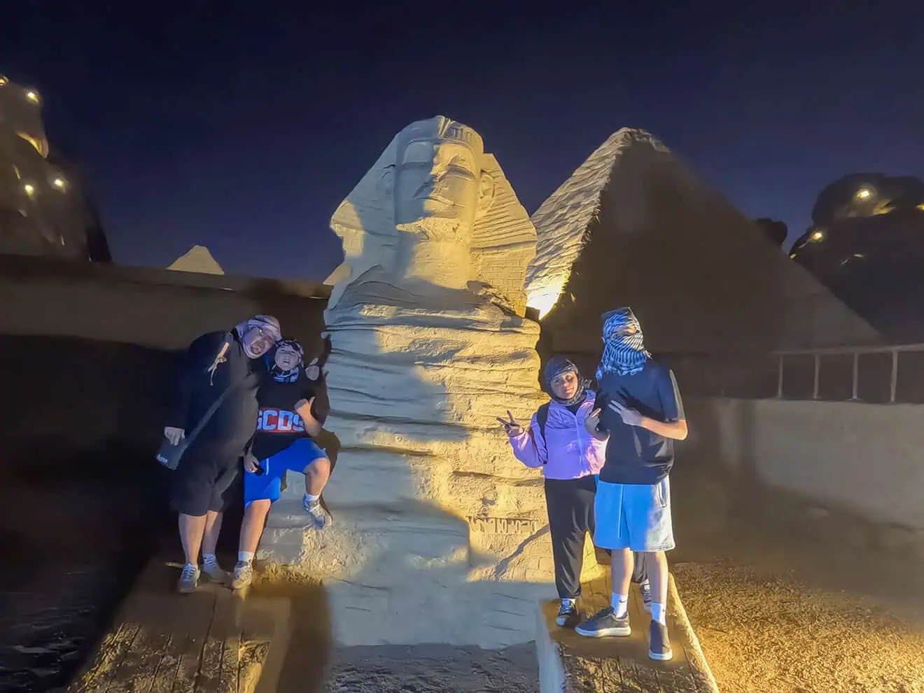 famiglia saluta davanti riproduzione della sfinge al piccolo egitto