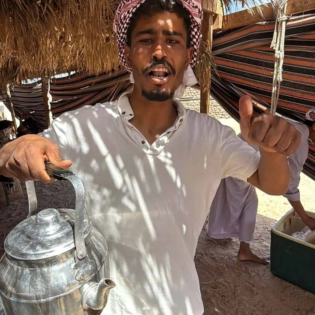 beduino sorride e tiene in mano teiera in una tenda a ras mohammed