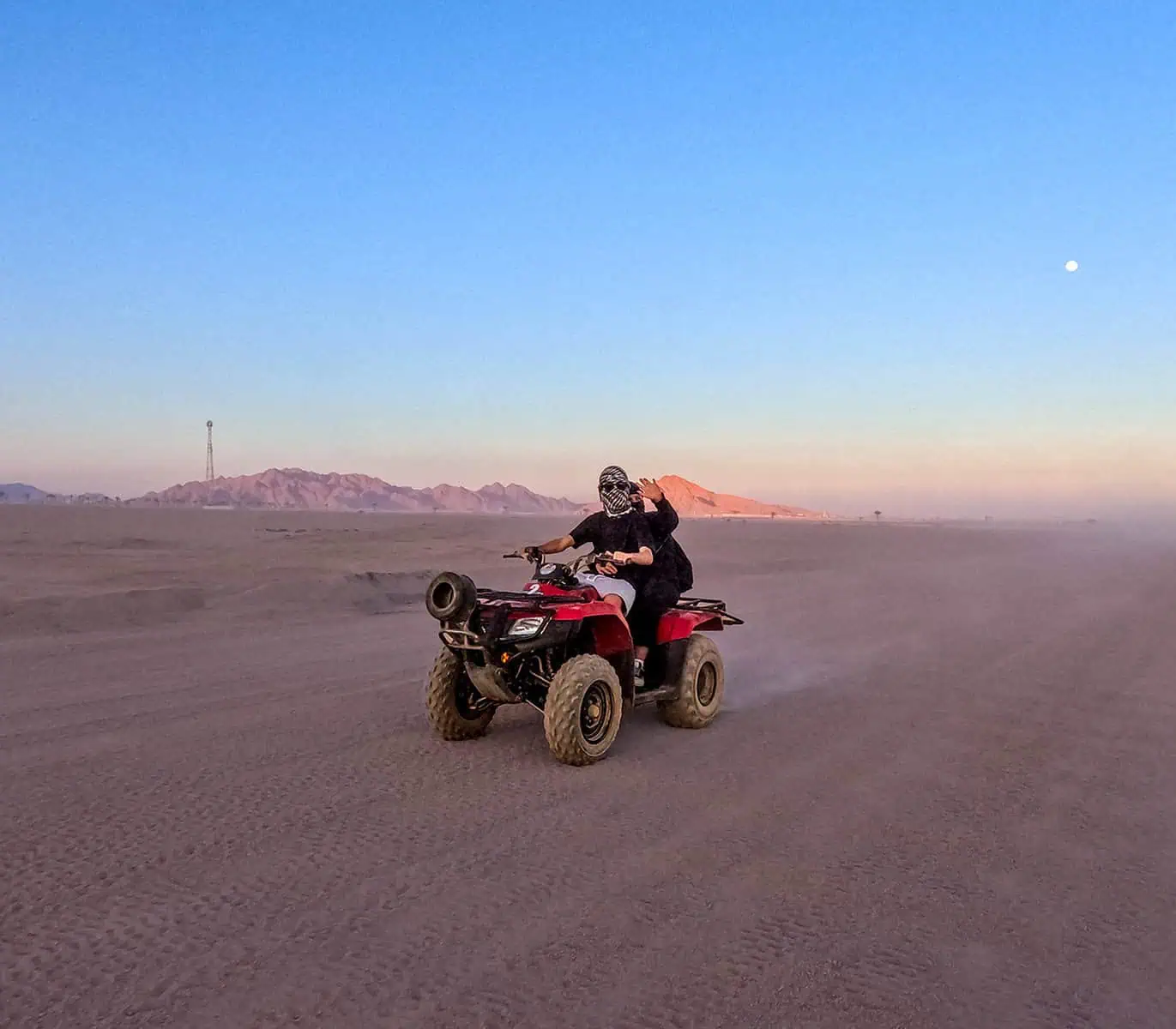 2 giovani in quad guidano nel deserto al tramonto durante la motorata