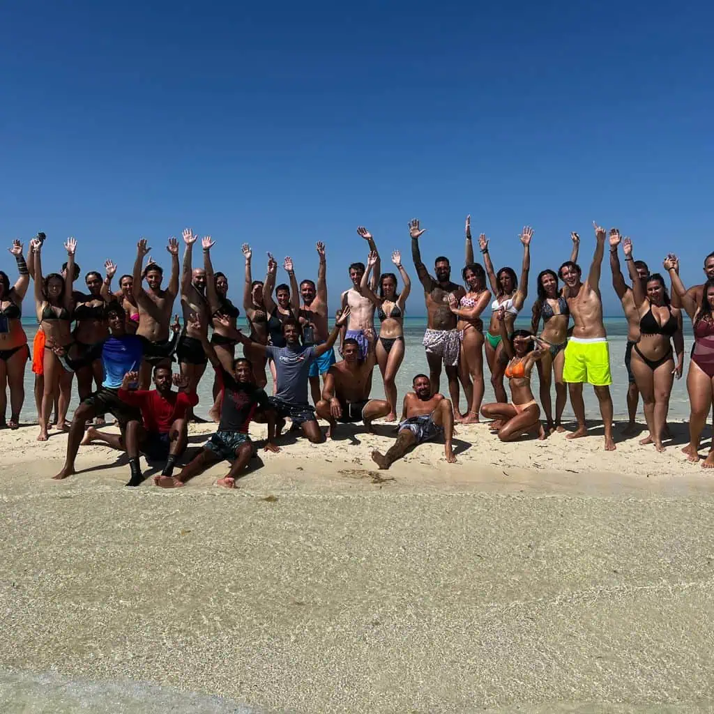 gruppo in costume alza le braccia all' isola che non c' e'