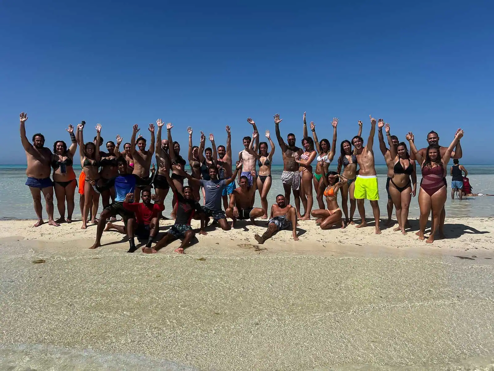 gruppo in costume alza le braccia all' isola che non c' e'