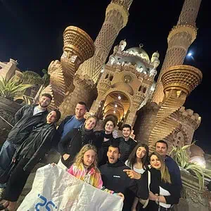 gruppo di italiani sorride davanti la moschea di sharm vecchia di sera