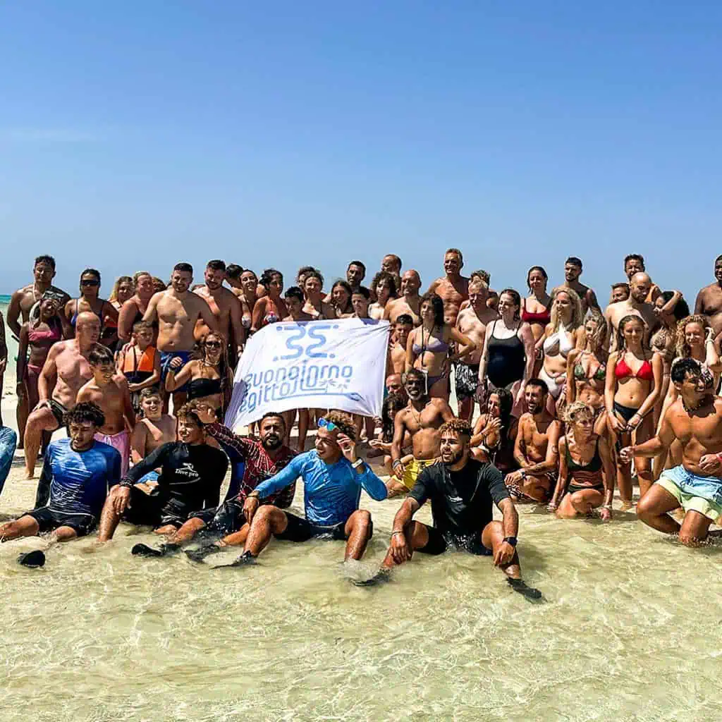 All' isola che non c' e' un gruppo di clienti con guida italiana e guida snorkeling in posa per una foto