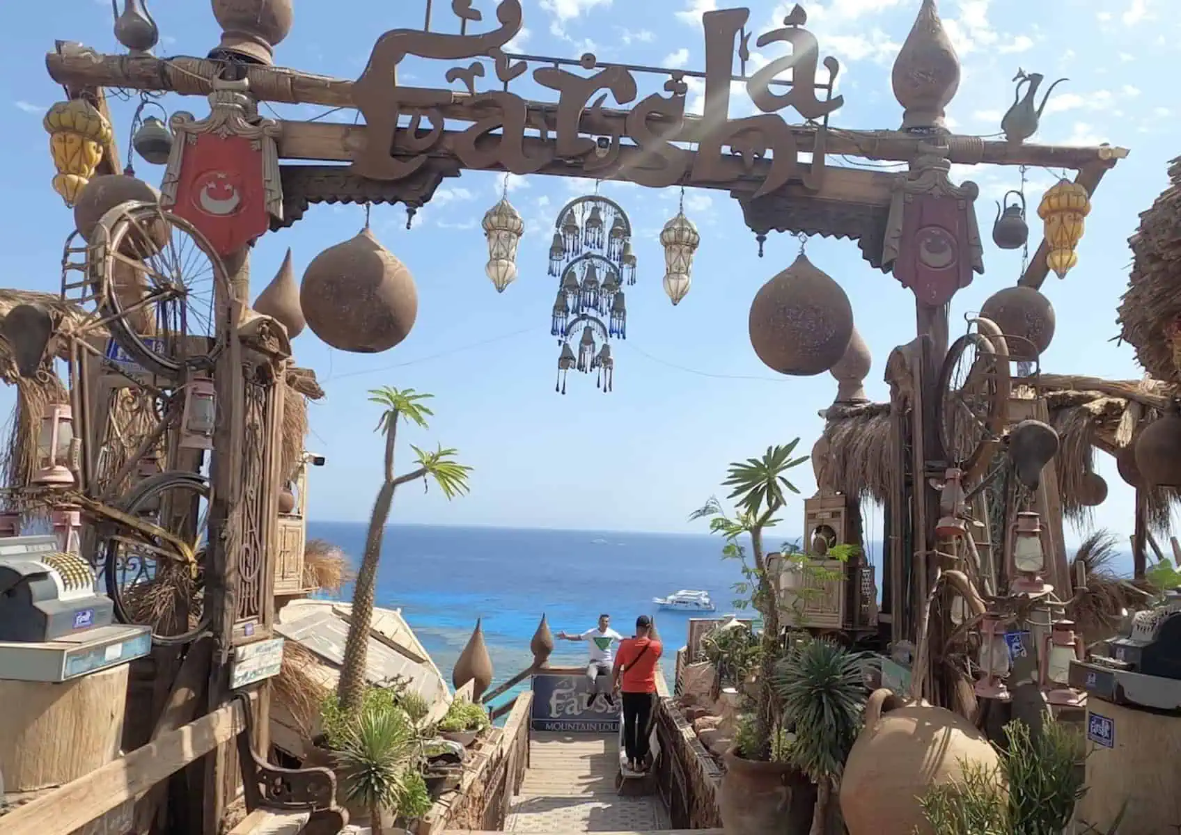 Entrata al Farsha cafe' con oggetti da collezione e mare all' orizzonte