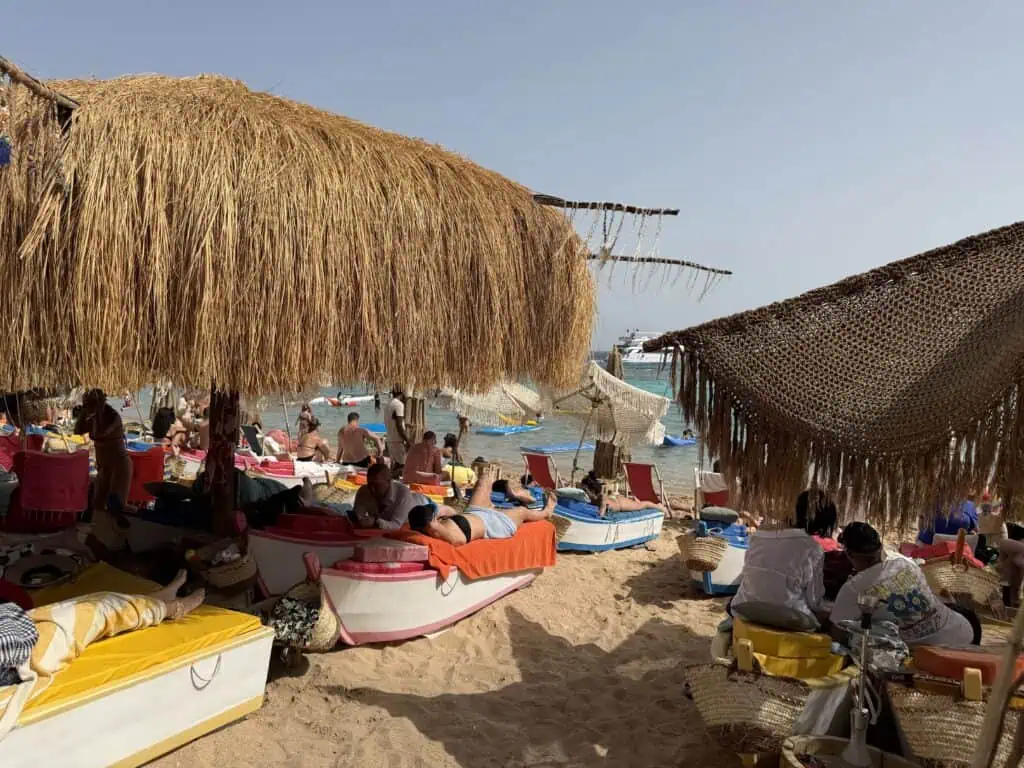 Vista dalla spiaggia con ombrelloni e lettini forma di barca